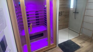 Een sauna met houten wanden en paars licht.