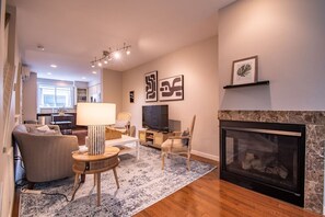 Ein Wohnzimmer mit Kamin, Fernseher und Essbereich.