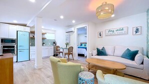 A modern apartment with a kitchen, dining area, and living room. - Tropical Charm Steps 2 Beach/Walk 2 Bridge St (Bradenton Beach)