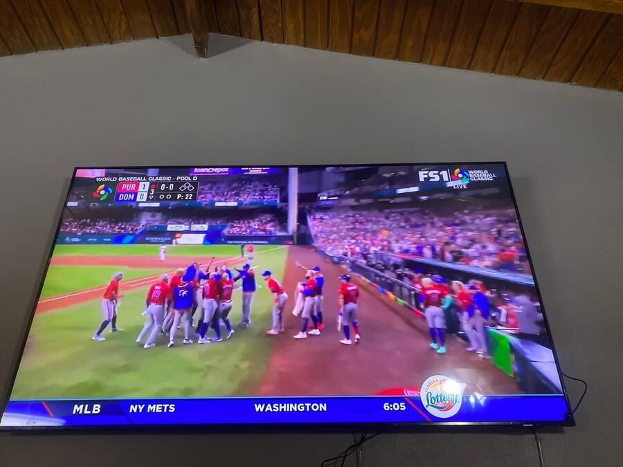A television displaying a baseball game with the score 1-0 in favor of the team in red.