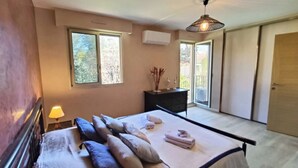 A bedroom with a bed, pillows, a dresser, a lamp, and a ceiling light.