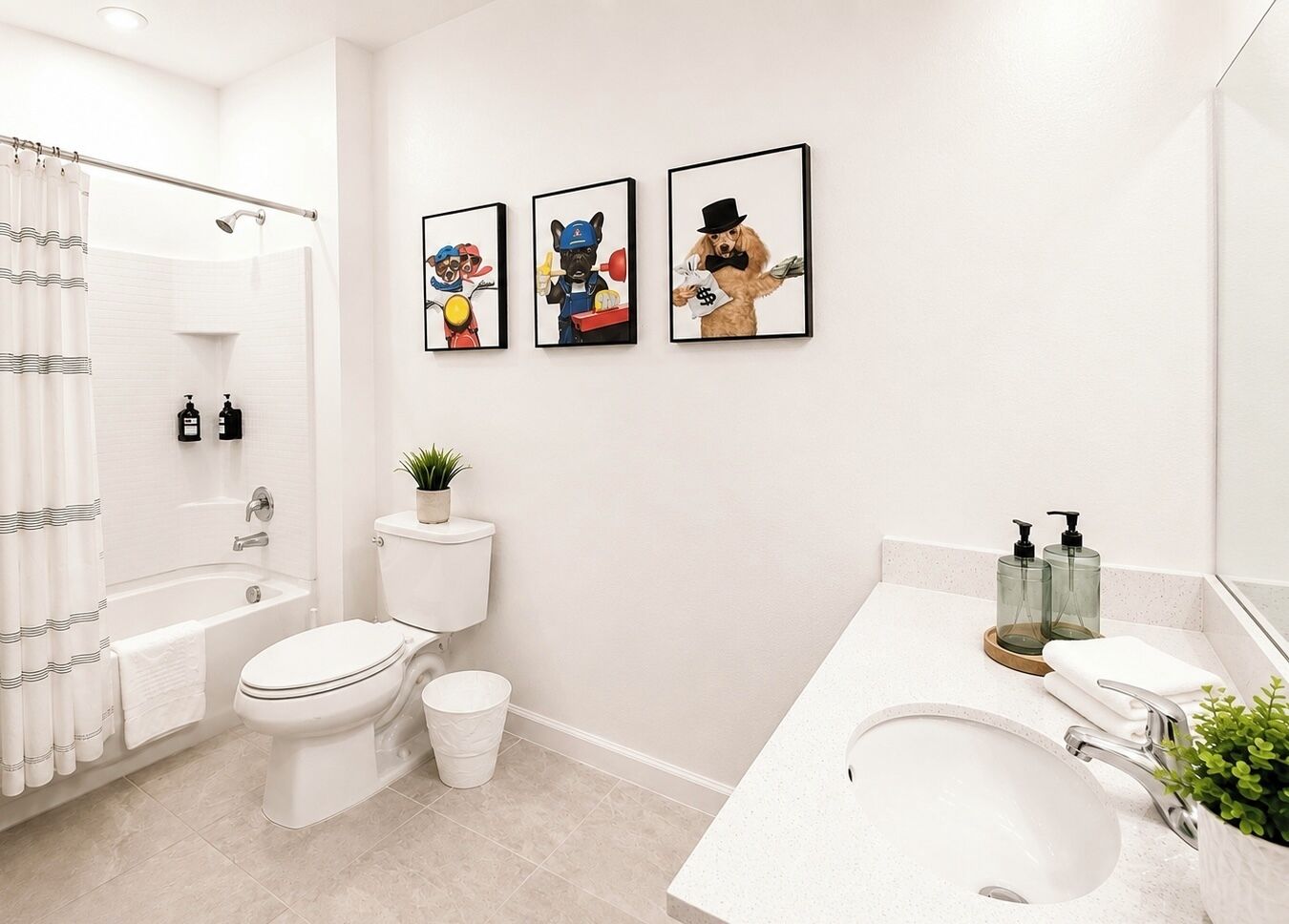 A modern bathroom with a bathtub, toilet, and sink. There are three framed pictures on the wall.