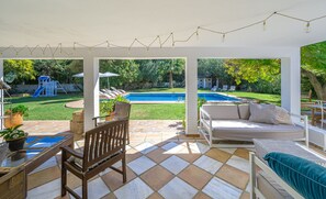 A covered patio area with a pool, outdoor furniture, and a play structure. - Beautiful house, a 5-minute walk from the beach (ESTEPONA)