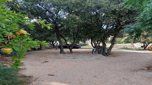 A gravel path leading to a bench under trees. - Apartments Paula - One Bedroom Apartment with Terrace 2 (Jezera)