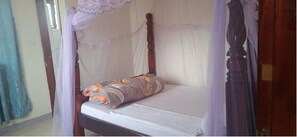 Cozy retreat with a single bed featuring a wooden frame and canopy.