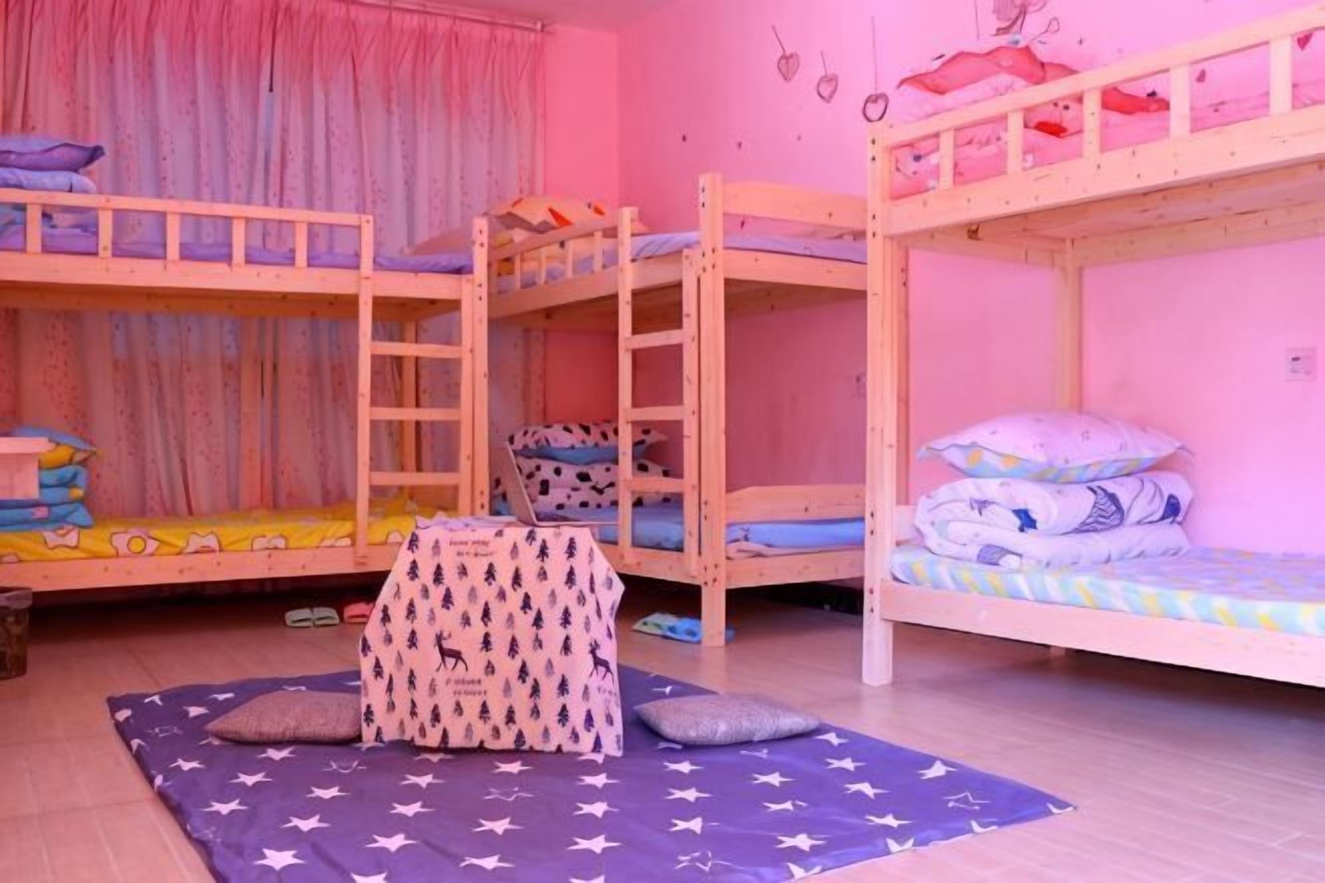 A bunk bed room with a ladder, pillows, and a star-patterned mat.