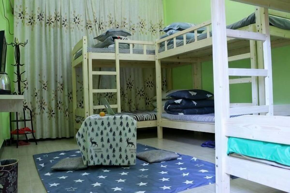 A bunk bed room with a desk, chair, and curtains.