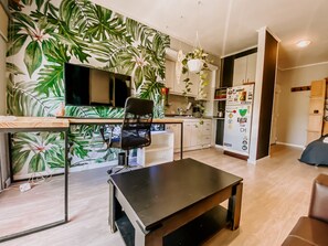 A modern kitchen with a large island, a dining area with a table and chairs, and a living space with a sofa. - Bright Studio with balcony, hammock and big desk (Paraná)