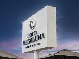 Señal de Hotel Mesaluna con un reloj y texto que indica que ofrece estancias cortas y largas.