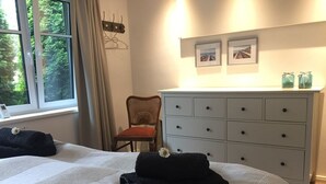 Ett hotellrum med två sängar, en byrå och en stol.