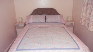 Una camera da letto con un letto, due comodini e un tavolino di fianco al letto.