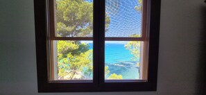 Una finestra amb vista a un paisatge costaner.
