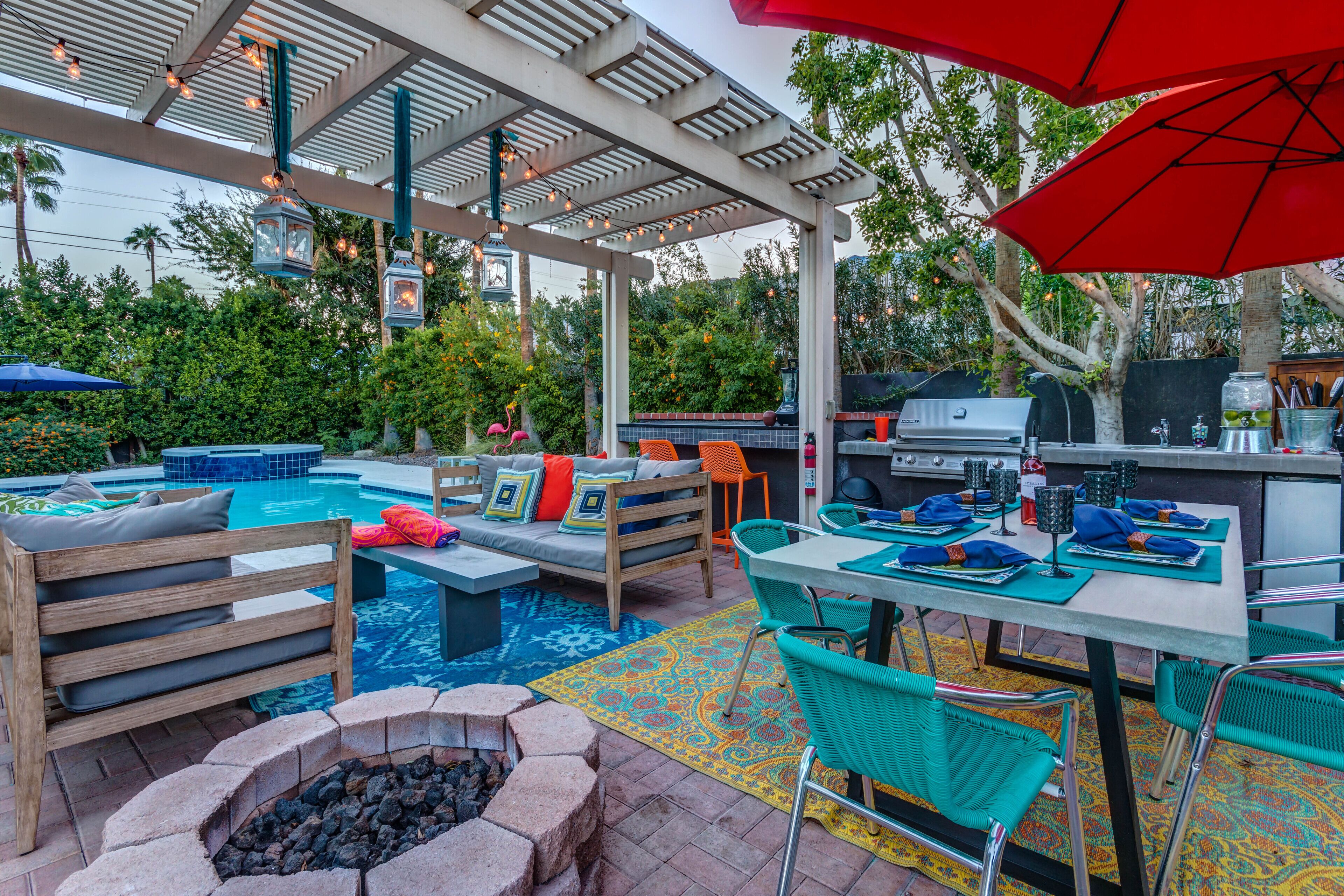 Un patio extérieur couvert avec une piscine, des sièges et un espace barbecue.