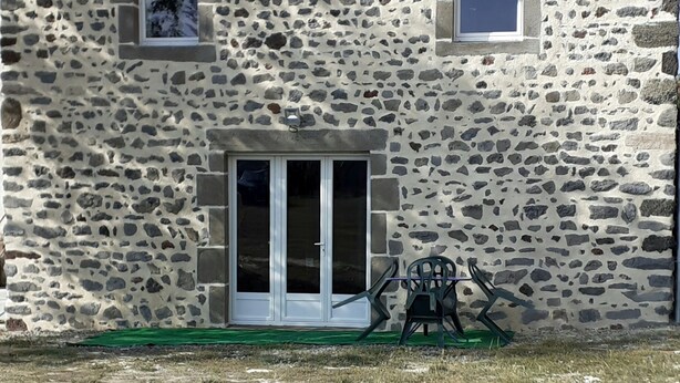 A stone building with a tiled roof, a central door, and two windows. - Petite Maison Moderne à la Campagne (Saint-Paulien)