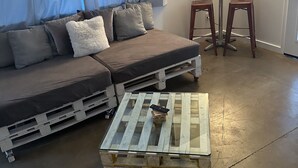 A living room with a sofa, a coffee table, and a lamp. - Home Away From Home (Reno)