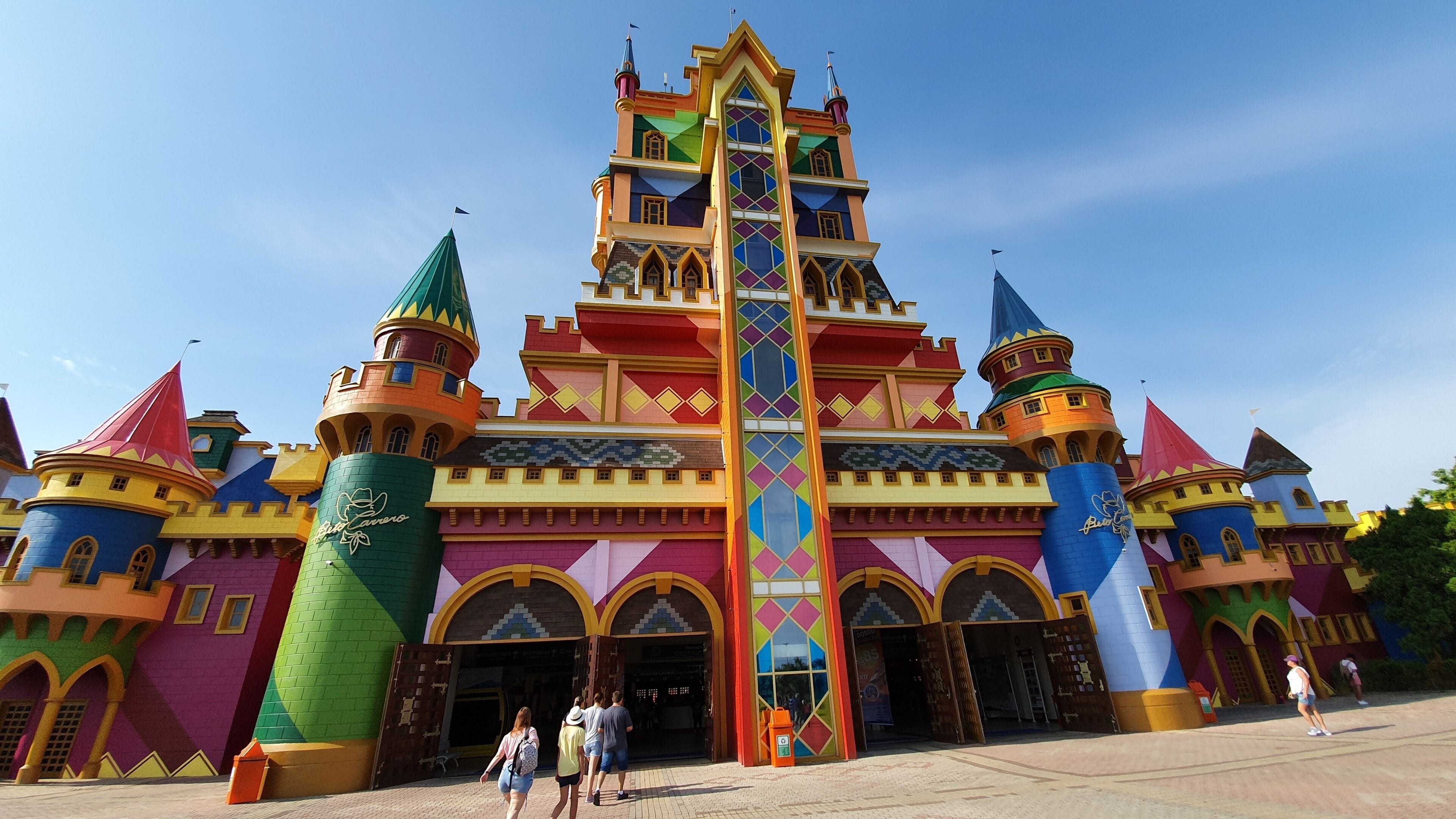 Un château aux couleurs vives, doté de nombreuses tours et d’une flèche centrale.