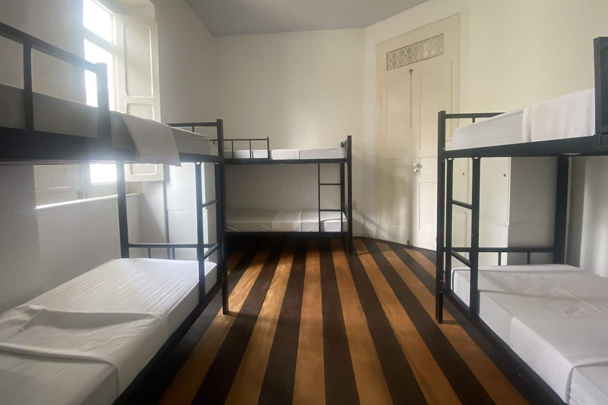 Ein Zimmer mit Etagenbetten, einem Streifenboden und einer weißen Tür.