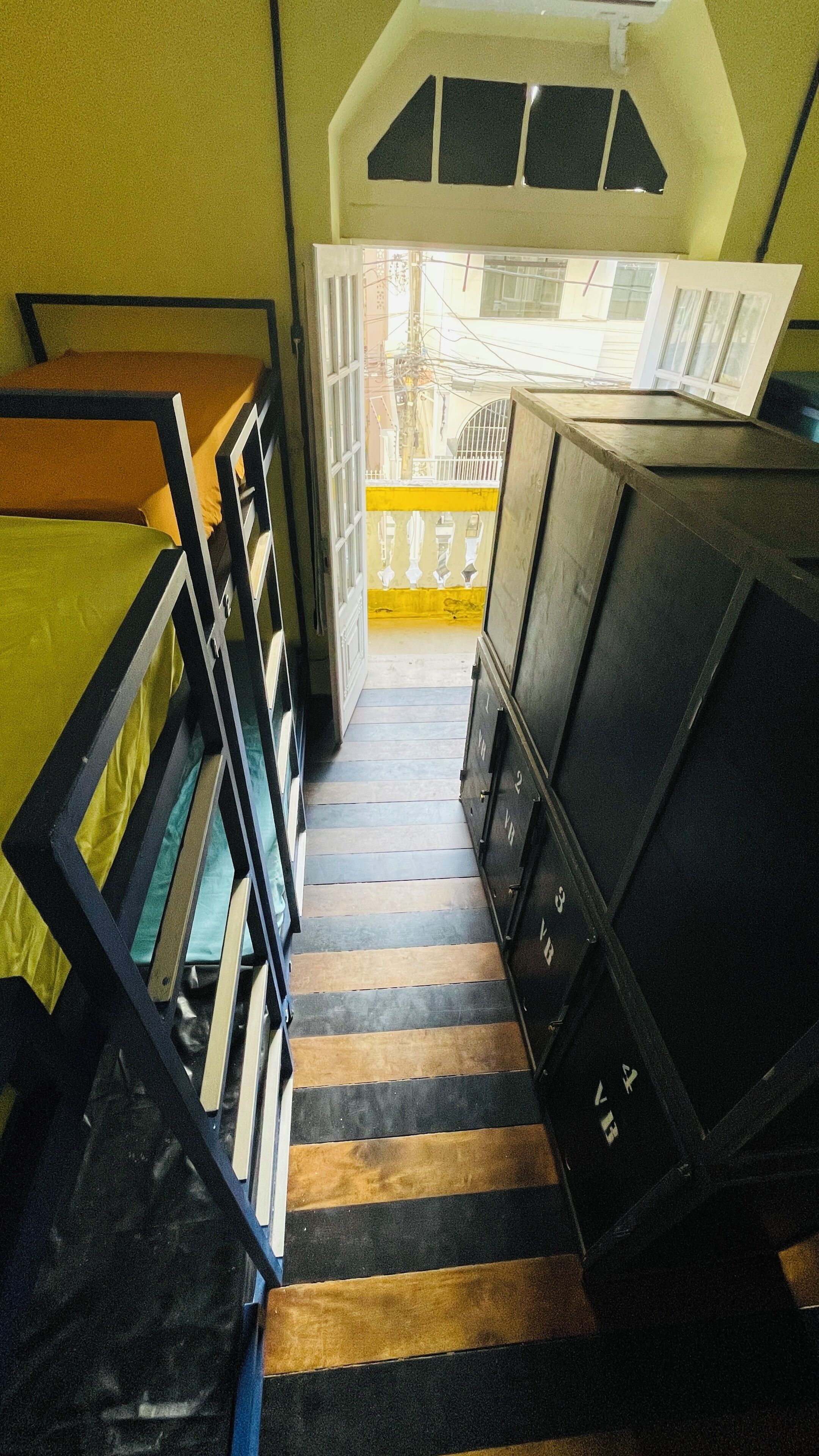 Eine Treppe mit gestreiftem Boden, die zu einer Tür mit gelbem Streifen führt.