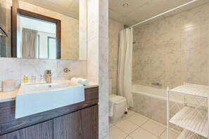Een moderne badkamer met een ruime badkuip, een aparte douche en een wastafelmeubel met een wastafel en spiegel.