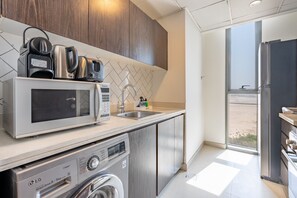 A modern kitchen with a microwave, coffee maker, and a steam iron.
