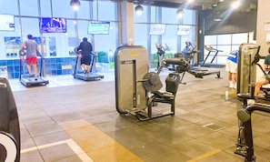 A gym with treadmills, weight machines, and exercise mats.