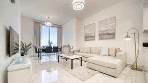 A modern living room with a sofa, coffee table, and dining area.