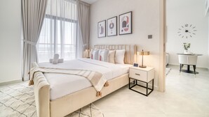Une chambre à coucher avec un lit, une table de chevet, une lampe et une horloge au mur.
