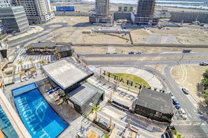 A rooftop pool area with a clear view of the surrounding cityscape, including roads and buildings.