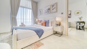 A modern bedroom with a large bed, bedside tables, a desk, and a chair. - Spectacular 1BR at Binghatti Avenue Al Jaddaf by Deluxe Holiday Homes (Dubai)