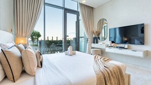 Ett modernt hotellrum med en stor säng, en platt-TV, ett skrivbord och utsikt över staden.