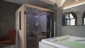 A modern bathroom with a large bathtub, a red chair, and a glass-enclosed shower area. - Palazzo Santo Spirito (Bergamo)
