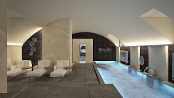 Uma área de spa com piscina, assentos e uma parede de pedra.