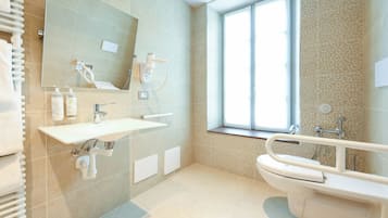 Ein modernes Badezimmer mit einem großen Spiegel, einem Waschbecken, einer Toilette und einem Fenster.