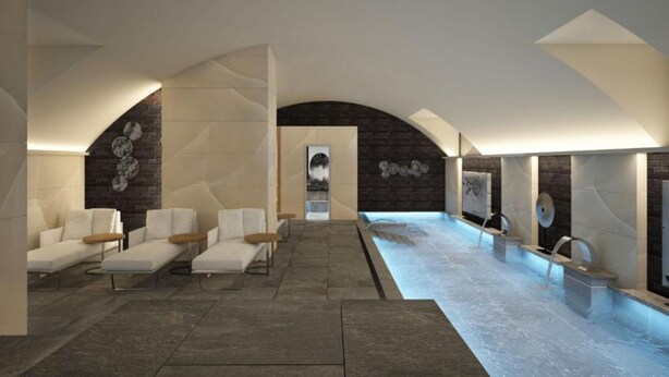 A modern spa with a large indoor pool, seating areas, and a central art installation. - Palazzo Santo Spirito (Bergamo)