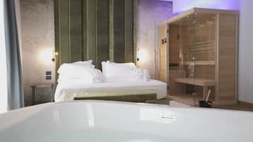Una habitación de hotel moderna con una cama grande, un armario de vidrio y una mesita de noche pequeña.