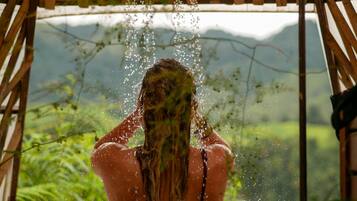 Una persona bajo una estructura de madera con gotas de agua visibles.