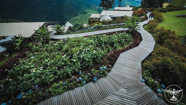 A garden pathway leading to a building with a view of a mountainous landscape. - El Nido del Cóndor Ecolodge (Villamaria)