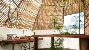 A bamboo ceiling with a wooden table and a woven basket. - El Nido del Cóndor Ecolodge (Villamaria)