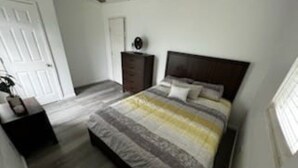 Ein Schlafzimmer mit Bett, Schminktisch und Deckenventilator.