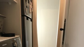 A laundry room with a Samsung washer and dryer, wooden flooring, and a door with a black handle. - Quiet house with enclosed garden and terrace 5 minutes from the beach! (Travo)