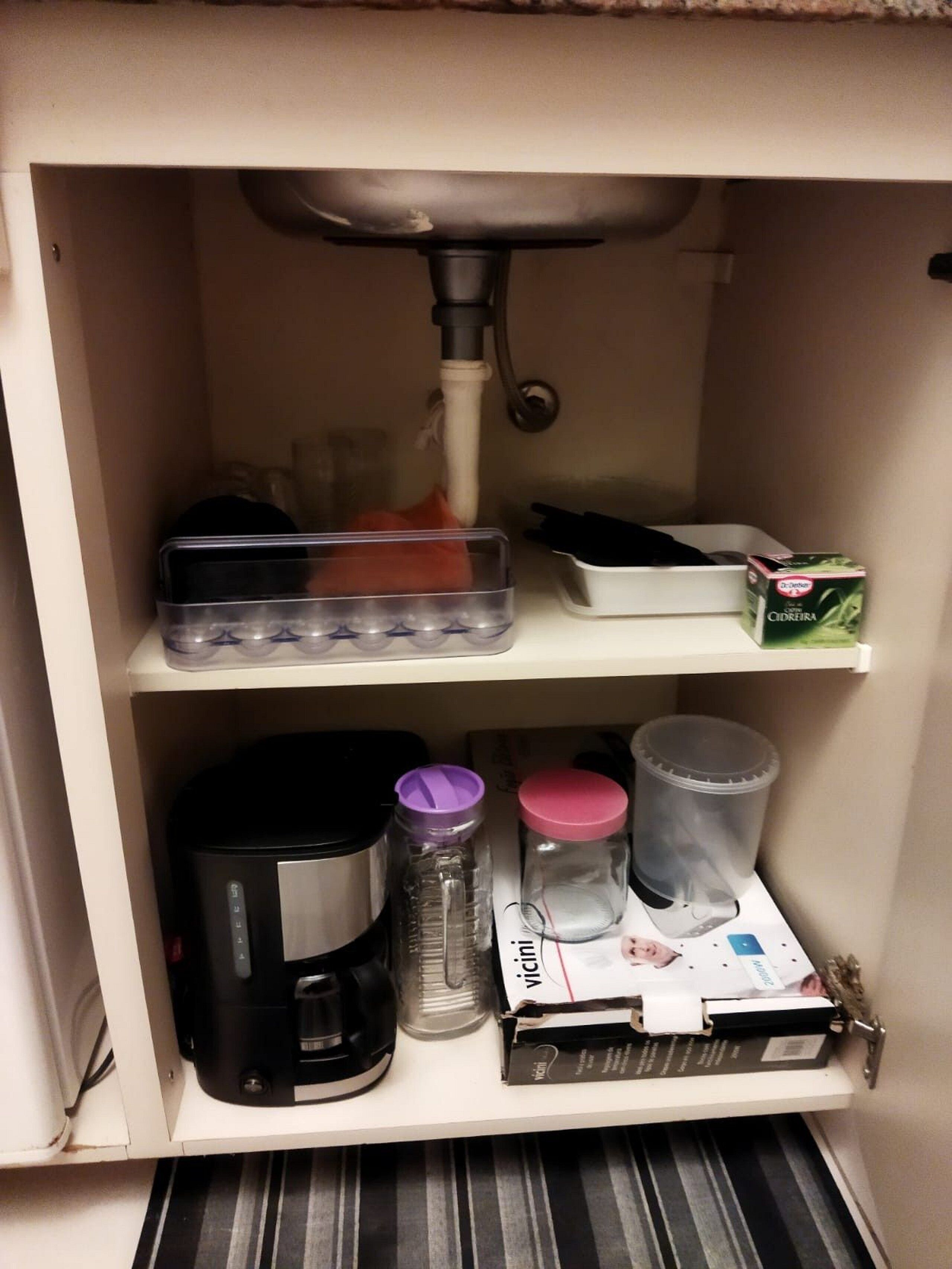 A kitchen area with a coffee maker, a water dispenser, and a box of Cidreira.