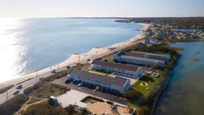 Luftaufnahme eines Hotels an der Küste mit mehreren Gebäuden, einem Strand und einer Straße.