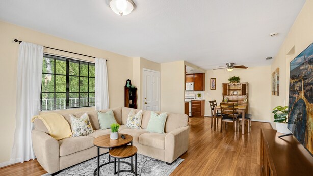 A living room with a beige sofa, a coffee table, and a dining area with a wooden table and chairs. - Cozy place in quaint, fun city (Sierra Madre)
