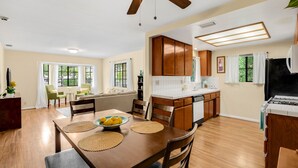 A modern kitchen with wooden cabinets, a dining area with a table and chairs, and a ceiling fan. - Cozy place in quaint, fun city (Sierra Madre)