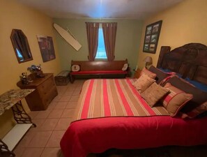 Cozy retreat with a large bed, wooden headboard, and a nightstand with a lamp.