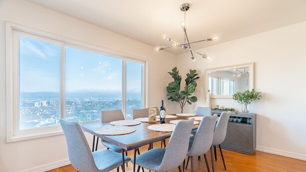 Un comedor con un amplio ventanal, una lámpara moderna y vistas a la ciudad.