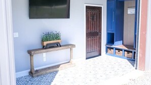 A hallway with a bench, a door, and a blue shelving unit with baskets. - Barndominium with Access to Horse Farm and Fishing (Comer)