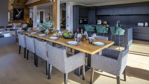 Een moderne eethoek met een houten tafel voor zes personen, omringd door rieten stoelen.