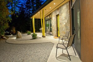 A modern building with a stone facade, yellow pillars, and outdoor seating.