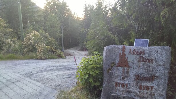A stone sign with the inscription 'Moon at Rand 5781 5787' and a solar panel. - Modern Forest Guest Suite - Accessible Seclusion! (Madeira Park)